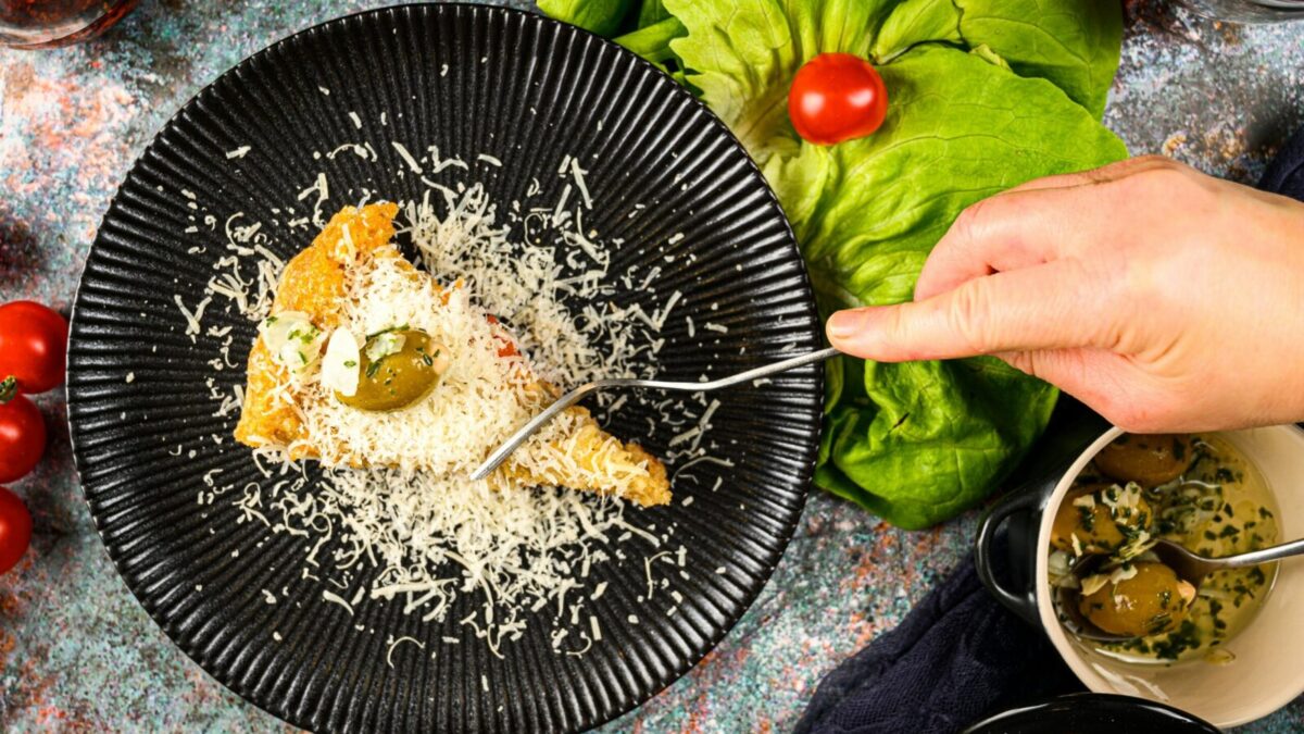 Delicious focaccia slice topped with cheese and olives on a stylish plate.