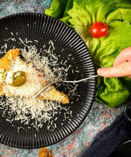 Delicious focaccia slice topped with cheese and olives on a stylish plate.