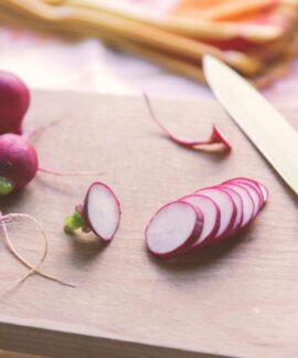 Freshly sliced radishes on a cutting board with a knife, perfect for healthy recipes.