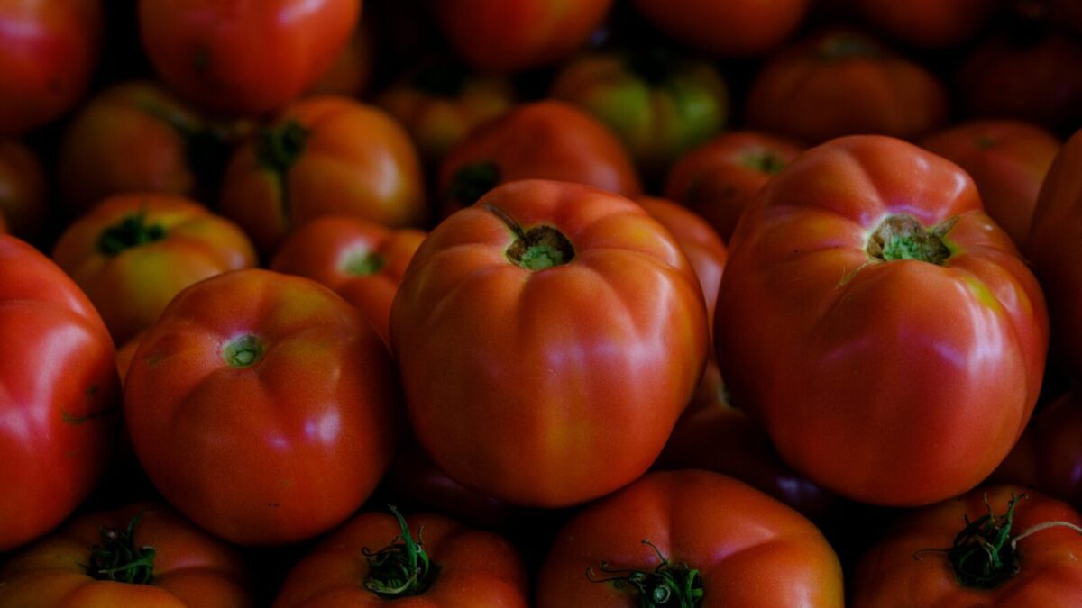 A vibrant close-up of fresh ripe tomatoes stacked together, showcasing their vivid colors.