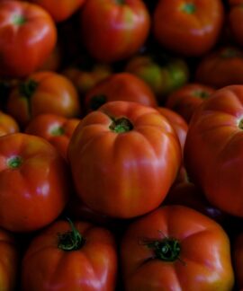 A vibrant close-up of fresh ripe tomatoes stacked together, showcasing their vivid colors.