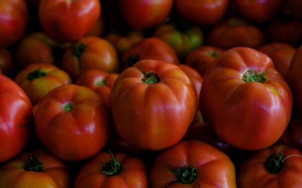 A vibrant close-up of fresh ripe tomatoes stacked together, showcasing their vivid colors.