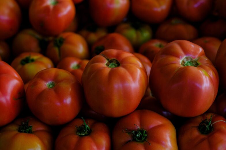 A vibrant close-up of fresh ripe tomatoes stacked together, showcasing their vivid colors.