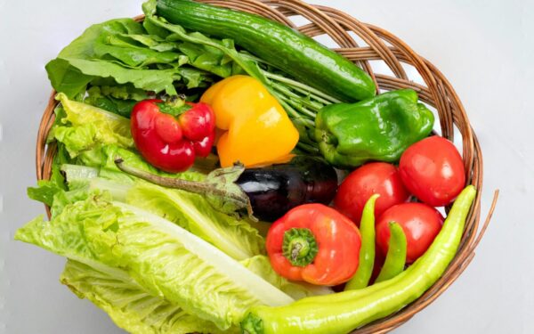 A vibrant assortment of fresh vegetables in a wicker basket. Ideal for healthy eating concepts.
