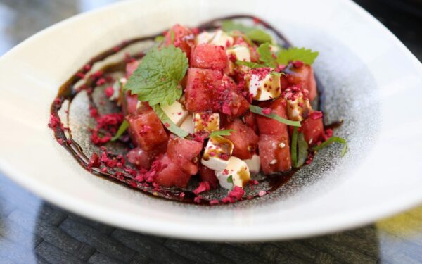 Close-up image of a vibrant watermelon and feta salad garnished with mint leaves.