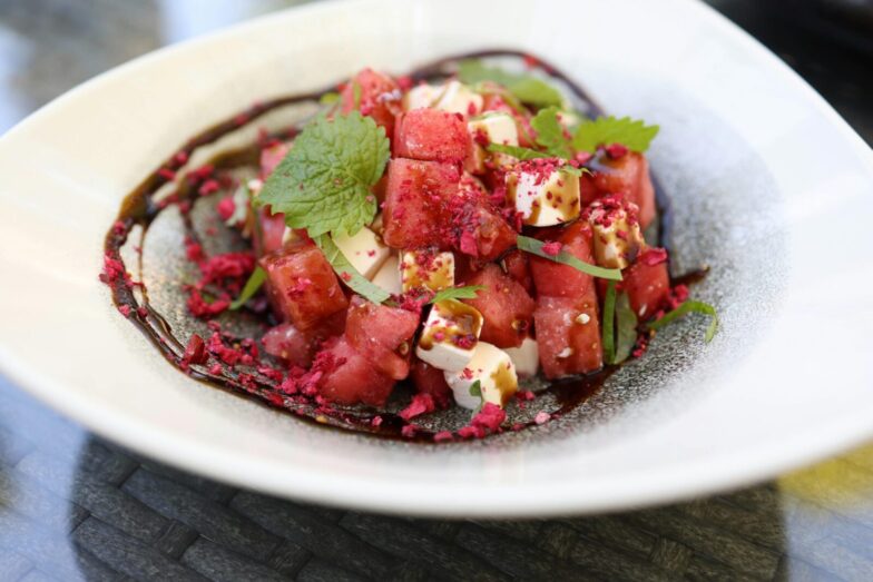 Close-up image of a vibrant watermelon and feta salad garnished with mint leaves.