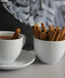 A cozy cup of coffee with cinnamon sticks on a table, creating a warm atmosphere.