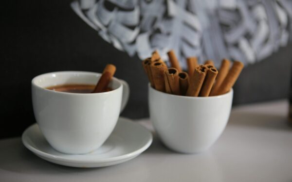 A cozy cup of coffee with cinnamon sticks on a table, creating a warm atmosphere.