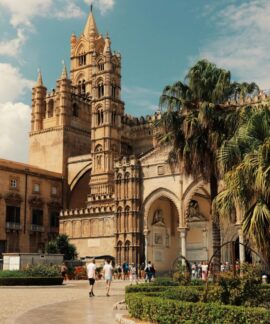 Explore the stunning architecture of Palermo Cathedral in Sicily, Italy, under a bright blue sky.