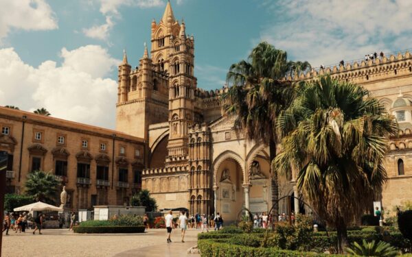 Explore the stunning architecture of Palermo Cathedral in Sicily, Italy, under a bright blue sky.