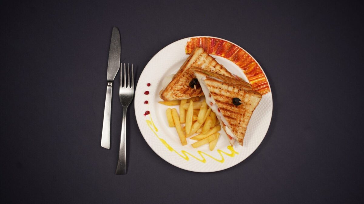 Delicious grilled toast and fries plated elegantly, shot in a studio on a black background.