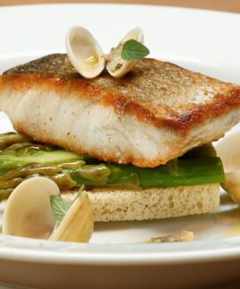 A gourmet fish dish served with clams and asparagus on a white plate.