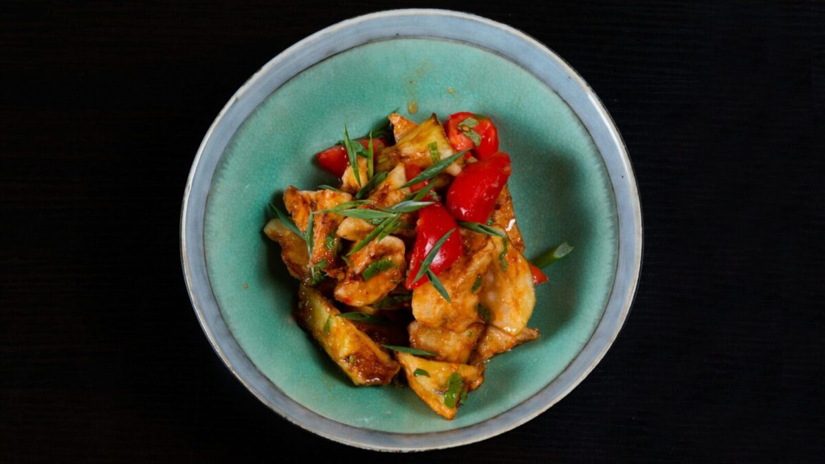 Delicious spicy chicken stir fry with colorful peppers served in a bowl. Perfect for a flavorful meal.