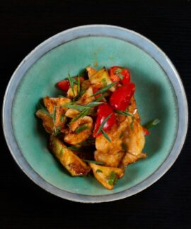 Delicious spicy chicken stir fry with colorful peppers served in a bowl. Perfect for a flavorful meal.