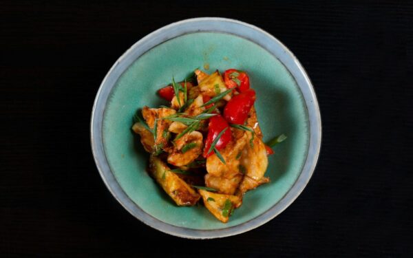 Delicious spicy chicken stir fry with colorful peppers served in a bowl. Perfect for a flavorful meal.