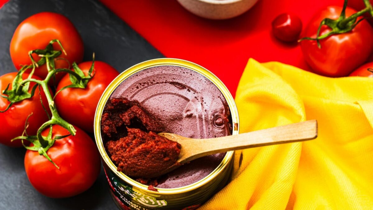 A colorful flat lay of fresh tomatoes and tomato paste in a bright and artistic presentation.