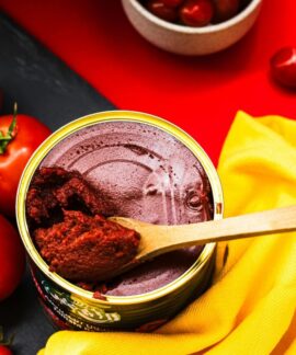A colorful flat lay of fresh tomatoes and tomato paste in a bright and artistic presentation.