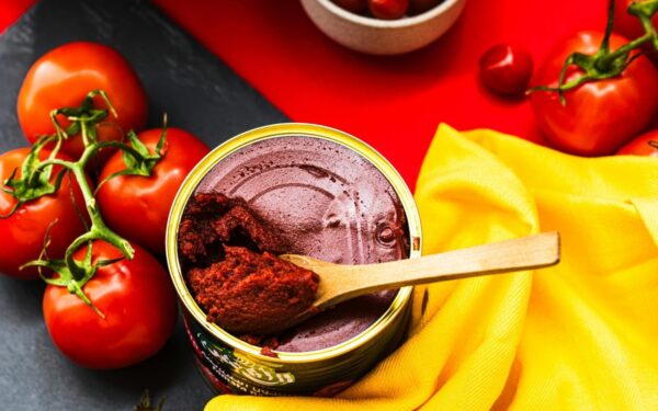 A colorful flat lay of fresh tomatoes and tomato paste in a bright and artistic presentation.