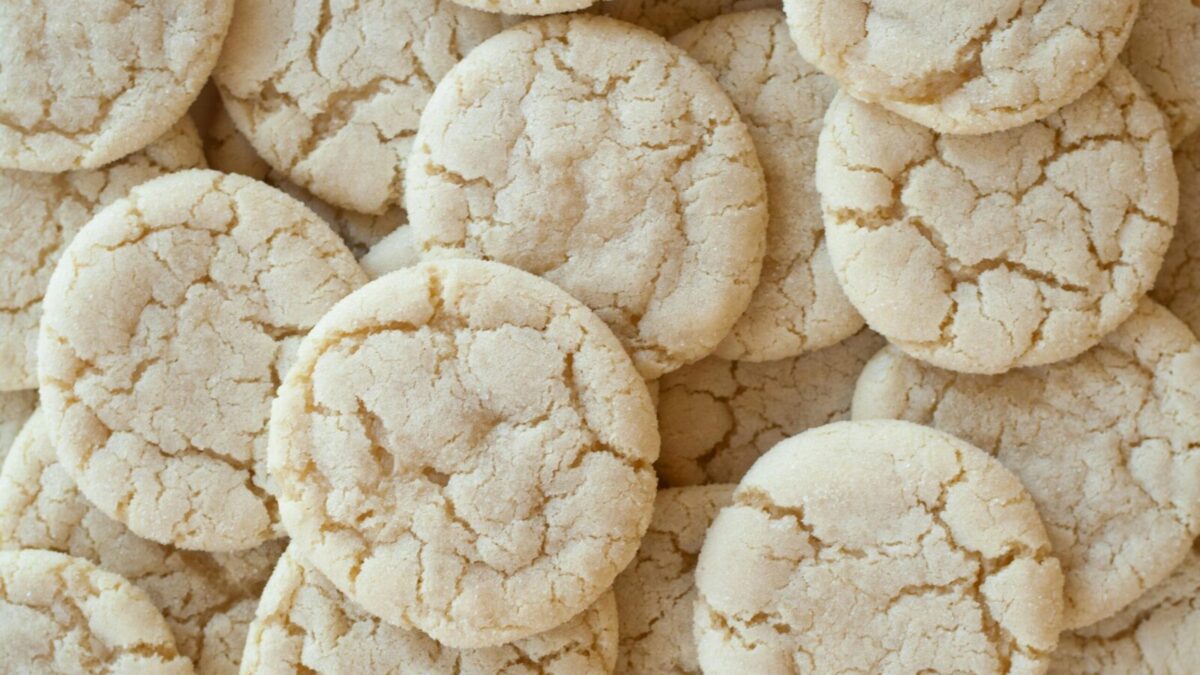 A close-up shot of homemade sugar cookies with a cracked surface, showcasing their texture.