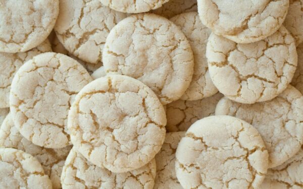 A close-up shot of homemade sugar cookies with a cracked surface, showcasing their texture.