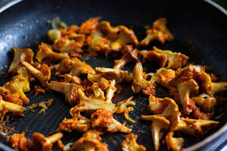 Delicious sautéed chanterelle mushrooms seasoned perfectly in a pan. Perfect for gourmet recipes.