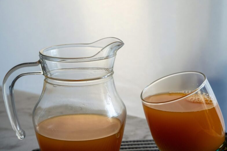 Refreshing orange juice served in a glass and jug, perfect for a healthy summer drink.