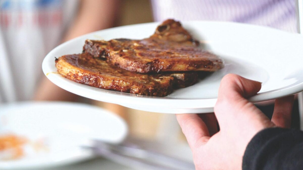 Juicy grilled pork chops served on a white plate, perfect for a tasty meal.