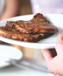 Juicy grilled pork chops served on a white plate, perfect for a tasty meal.