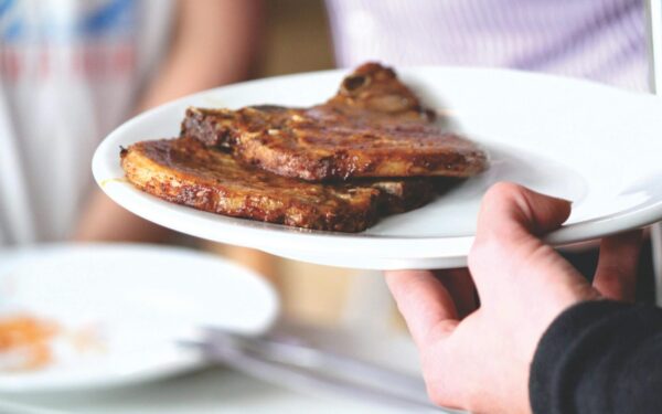 Juicy grilled pork chops served on a white plate, perfect for a tasty meal.