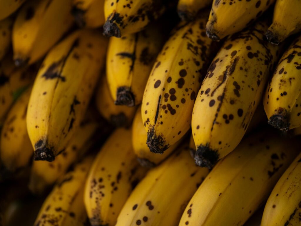 Detailed close-up of ripe yellow bananas with brown spots, perfect for healthy eating concepts.