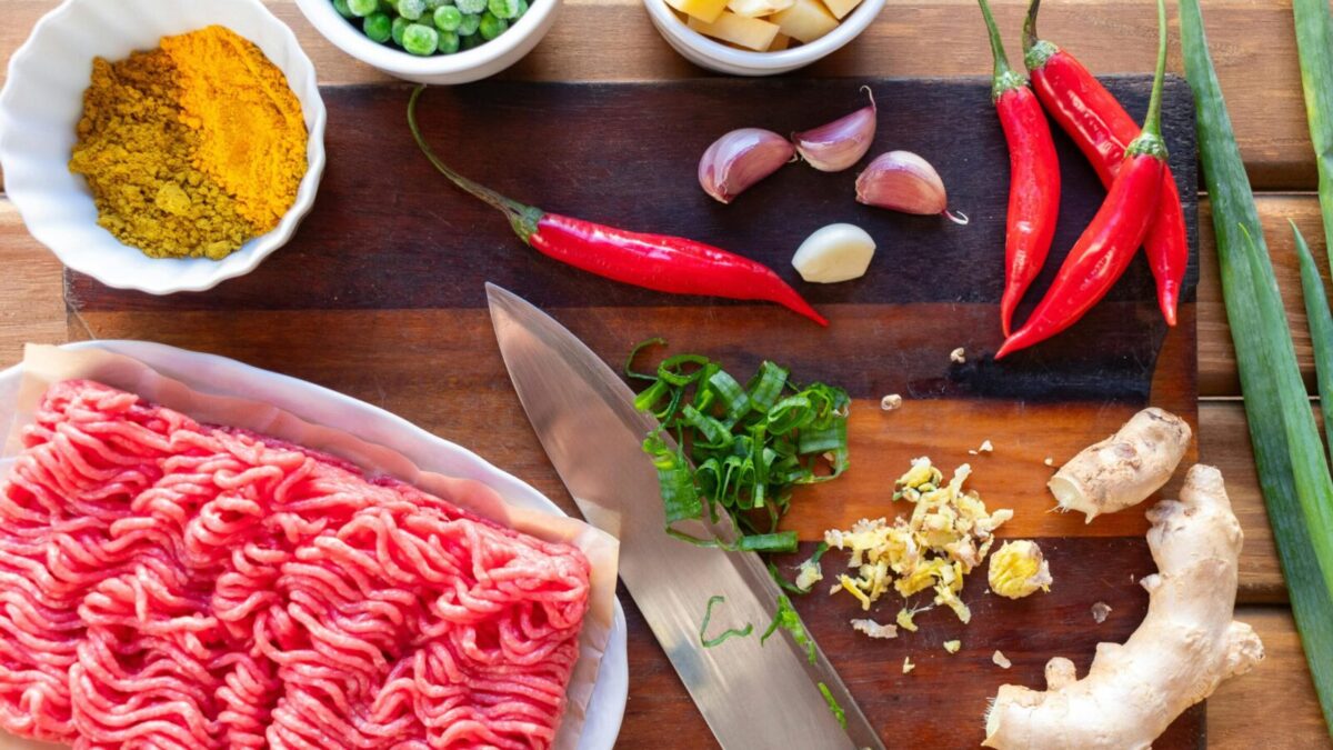 Fresh ingredients displayed on a cutting board, perfect for preparing a spicy beef stir fry.