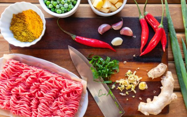 Fresh ingredients displayed on a cutting board, perfect for preparing a spicy beef stir fry.