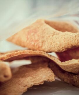 Close-up image of crunchy, golden brown pork rind snack, showcasing texture and detail.