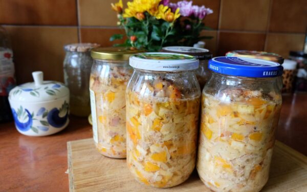 Colorful homemade pickled vegetables sealed in jars, displayed on a kitchen countertop.