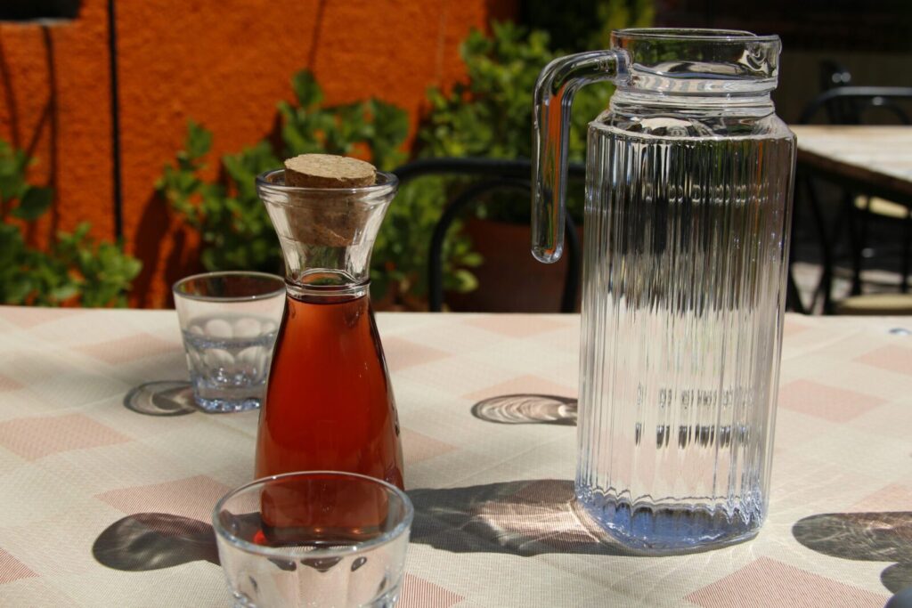 A sunny outdoor table setting featuring glassware and plants, perfect for summer dining.