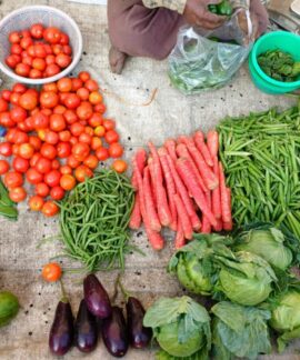 A vibrant display of fresh vegetables at an outdoor market stall.