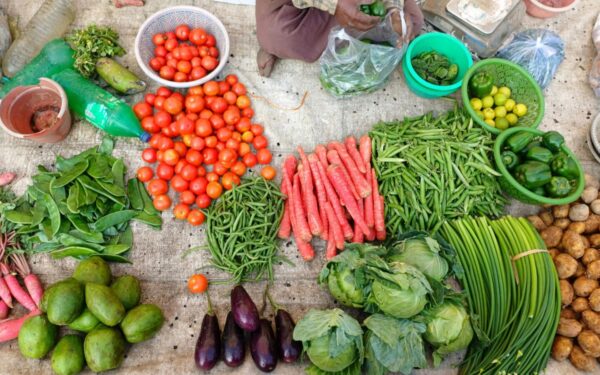 A vibrant display of fresh vegetables at an outdoor market stall.