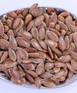 High-resolution close-up of flaxseeds on a metal spoon, showcasing detail and texture.