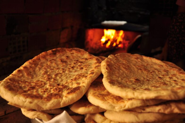 Freshly baked pita bread in a rustic Turkish oven, showcasing traditional baking methods.