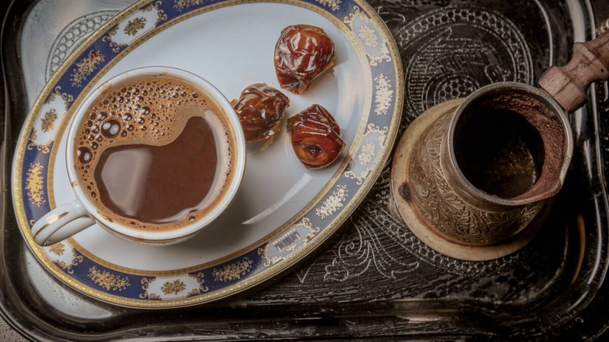 A close-up of traditional Turkish coffee with dates on an ornate serving tray for a cultural experience.