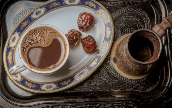 A close-up of traditional Turkish coffee with dates on an ornate serving tray for a cultural experience.