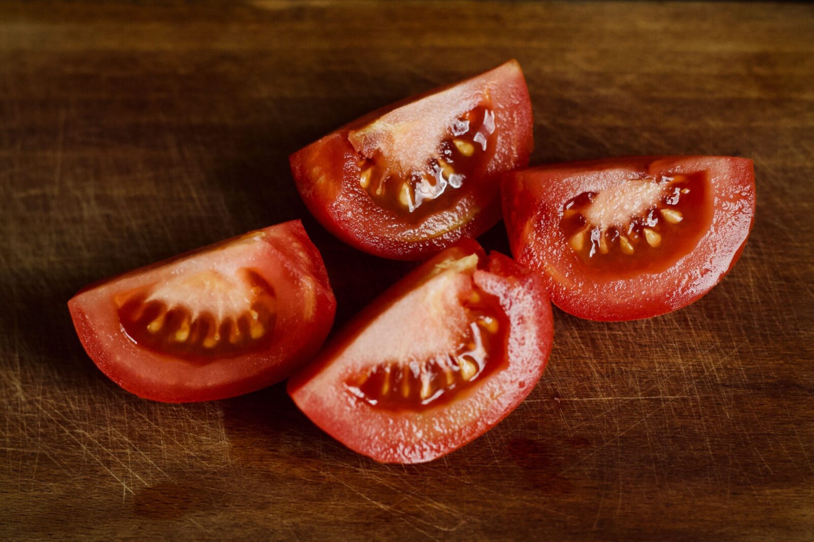 High-quality image of tomato slices on a wooden board, perfect for culinary or nutritional themes.