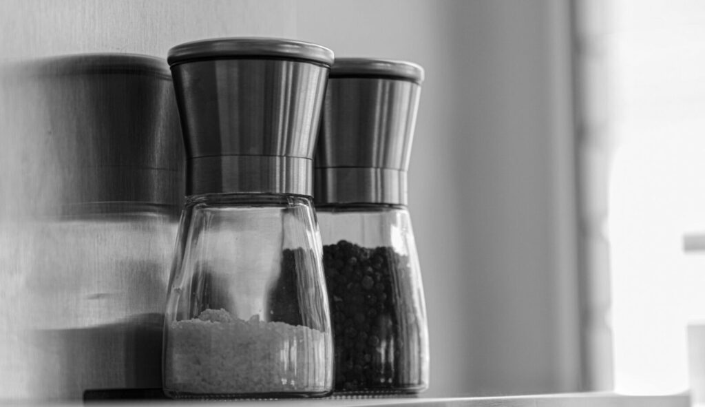 Close-up of sleek salt and pepper shakers on a kitchen shelf in Berlin.