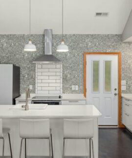 A sleek modern kitchen features a white island, vibrant fridge, and elegant lighting for a contemporary look.