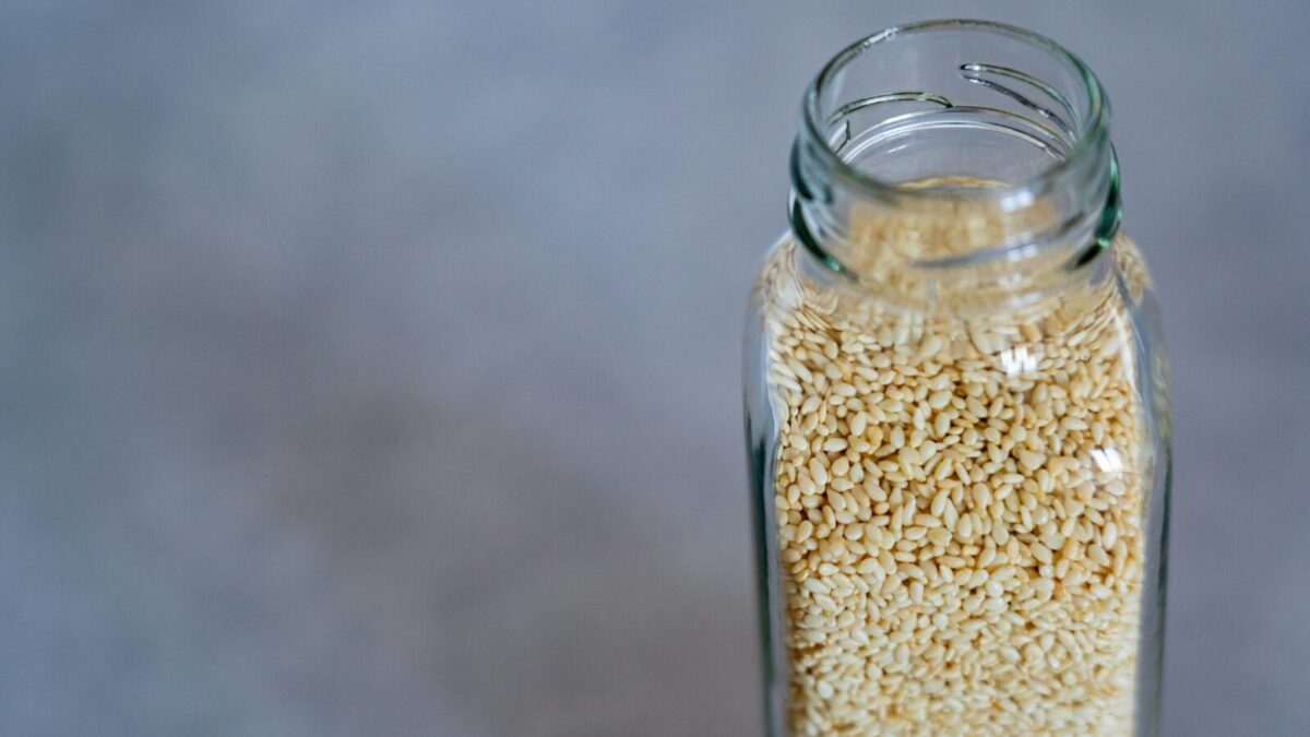 Close-up of a glass jar filled with sesame seeds, perfect for food photography and healthy lifestyle concepts.
