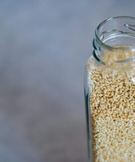 Close-up of a glass jar filled with sesame seeds, perfect for food photography and healthy lifestyle concepts.