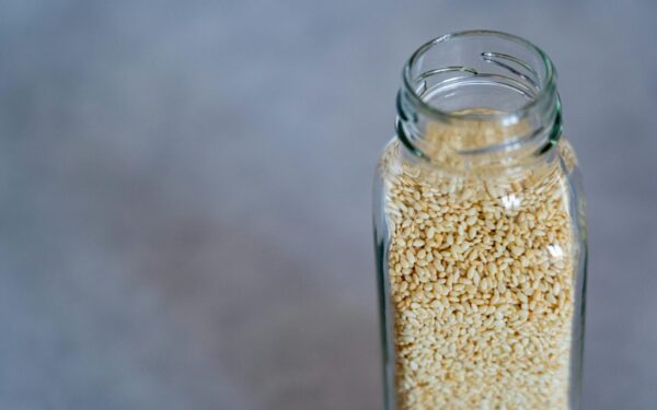 Close-up of a glass jar filled with sesame seeds, perfect for food photography and healthy lifestyle concepts.