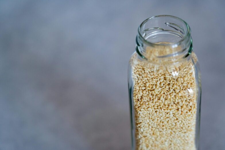 Close-up of a glass jar filled with sesame seeds, perfect for food photography and healthy lifestyle concepts.