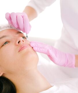 Woman receives cosmetic injection in clinical setting, enhancing beauty using modern techniques.