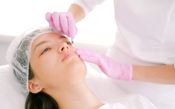 Woman receives cosmetic injection in clinical setting, enhancing beauty using modern techniques.